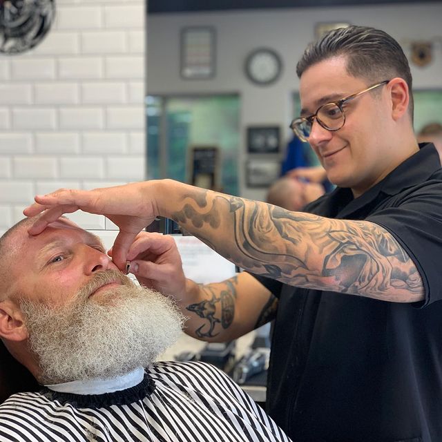 Barber giving a mens haircut in a barber shop